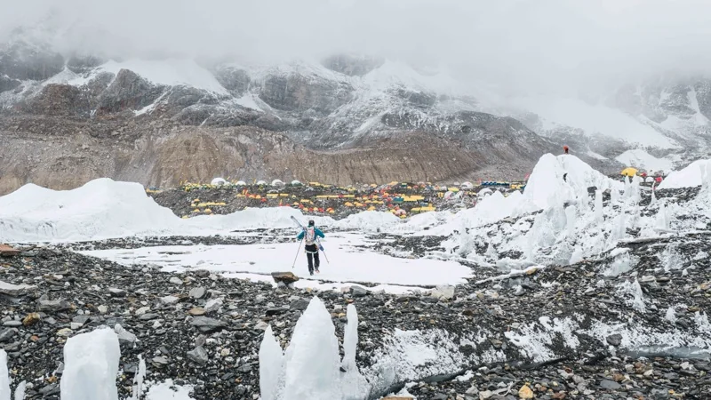 A skier walking across the moraine to Base Camp