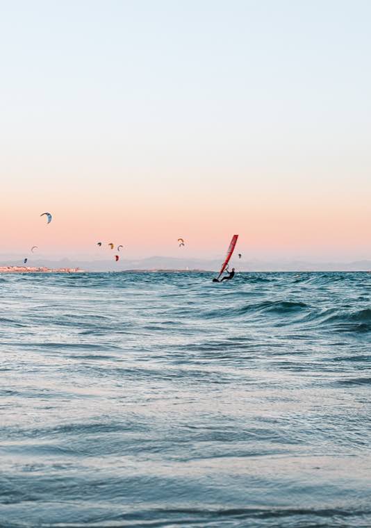 Windsurfer na falach o zachodzie słońca